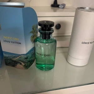Pacific Chill parfym från Louis Vuitton - Lyxig parfym från Louis Vuitton, Pacific Chill, i en elegant grön glasflaska med svart spraymunstycke och lock med LV-logga. Kommer med originalförpackning och vit cylinderask. Doften ger en fräsch och exklusiv känsla.