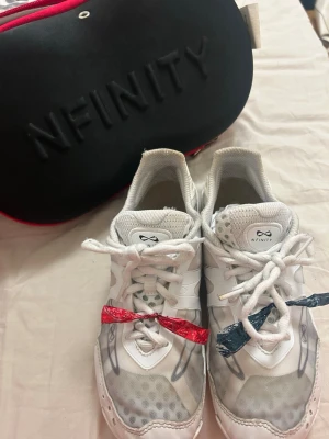 Nfinity Vengeance cheerleading skor - Säljer ett par vita Nfinity Vengeance cheerleadingskor. Det har använts i ett år och säljer för att de har växts ur. De är alltså inte trasiga eller liknande men det finns ett litet ställe på sista bilden där det har gåt upp lite men det gör ingen skillnad i skon. Väldigt bra och populära skor.               Storlek 6.5 vilket är ungefär 37. Pris går att diskutera 🤗
