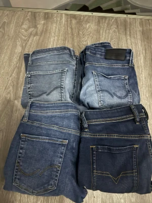 Fyra par blå jeans i olika tvättar - Säljer fyra par klassiska blå jeans i olika tvättar, från ljusblå till mörkblå. Alla har raka ben och bakfickor med dekorativa sömmar. Perfekta för dig som vill ha flera stilar att variera mellan. Materialet är denim med tydliga kontrastsömmar. Det finns 3 jack and Jones och en diesel alla är jätte feta skriv till mig om ni undrar nått.