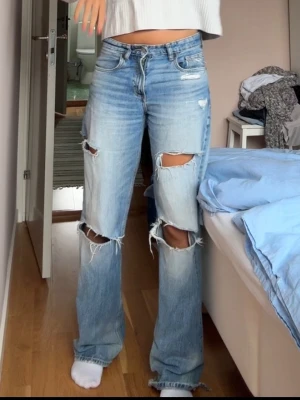 Blå Lågmidjade jeans med hål - Jättesnygga blåa jeans från Zara, som inte längre säljs på Zara. Säljer för att dom inte kommer till användning! Skriv om ni har frågor!