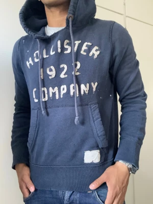Vintage Hollister Hoodie - Extremt sällsynt och unik Hollister Hoodie med tryck | Hoodien har en unik sliten & distressed design! | Mycket bra skick, förutom fläckigt på vänsta ärmen, se sista bild| Storlek S | Längd≈ 65 cm, Bredd 52 cm under armhål-armhåla| Modell 175cm, 68kg | Priset ej hugget i sten! 