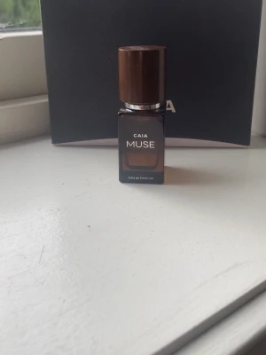 CAIA Muse Eau de Parfum 15ml - Säljer en CAIA Muse Eau de Parfum i en stilren brun glasflaska med mörkbrunt lock. Flaskan har en modern, fyrkantig form och rymmer 15 ml. Perfekt att ha med i väskan för en fräsch doft när du är på språng. Helt oanvänd och pris kan diskuteras 💕