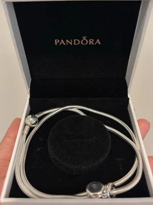 Silverhalsband från Pandora - Säljer ett Pandora silver halsband med en berlock till☺️Den är helt oanvänd och är i perfekt skick. Kan sälja halsbandet tillsammans med berlocken, men även sälja båda separat. Det är bara att skriva till mig isåfall✨Halsbandet försig ligger på 1 199kr och berlocken ligger på 499kr, priset för båda står i inlägget. Jag är även öppen för att diskutera kring priset💛 Lådan på bilden medföljer vid köp av halsbandet☺️