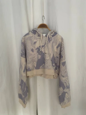 Croppad barnhoodie med lila swirl-design - Från Monkl. Någorlunda sparsamt använd, men har inge några hål eller fläckar. Storlek S. 60% bomull och 40% polyester.