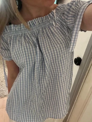 Blåvit offshoulder blus med rutor - Söt offshoulder blus i blåvitt rutigt mönster. Lite målarfärg på ärmen, se sista bild. 💕🤞