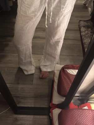 Vita linnebyxor med dragsko - Säljer ett par vita linnebyxor med raka ben och dragsko i midjan. Byxorna har två framfickor och är tillverkade i ett luftigt linnematerial, perfekta för en avslappnad och stilren look. Storlek m men passar mig som vanligtvis har 34 i byxor