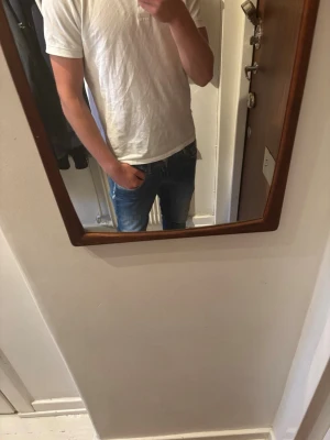 Blå  slim fit jeans herr från replay - Säljer ett par klassiska blå slim fit jeans från replay med normal midja och smal passform. Jeansen har fem fickor och snygga kontrastsömmar. Perfekta till vardagslooken och passar till det mesta i garderoben. De är i storlek 30/30 och har ett litet hål på vänsterben. 