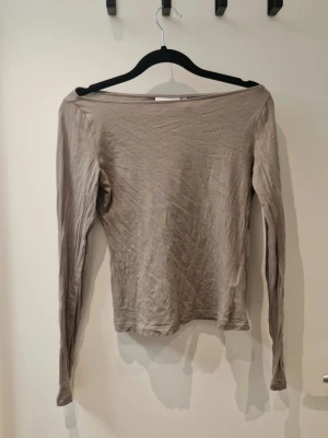 Grå sheer topp - Tunt lite seethrough material. Har en båtringning. Säljer då jag inte tyckte färgen passade mig. Skrynklig då den är nytvättad.