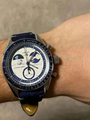 Omega x Swatch Speedmaster klocka blå - Snygg Omega x Swatch Speedmaster, snoop klocka med blå ram och vit urtavla. Klockan har detaljer i blått och silver samt en unik månfasdesign, och ett extra metall case Urtavlan har flera små visare och tachymeter på ramen. Matchande blått band i textil, bandet är lite ljusare än vad den ser ut på bilderna