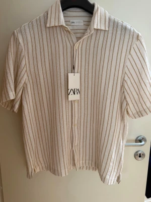 Kortärmad skjorta från Zara  - Helt oanvänd kortärmad skjorta från Zara med prislappen kvar. Den är i storlek S men skulle säga att den är lite luftigare i modellen. 