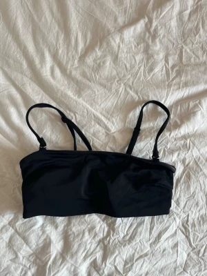 Svart basic bikiniöverdel - Snygg svart basic bikiniöverdel med inlägg,  justerbara axelband och enkel knäppning i ryggen. Stilren och klassisk modell som passar till det mesta!💕