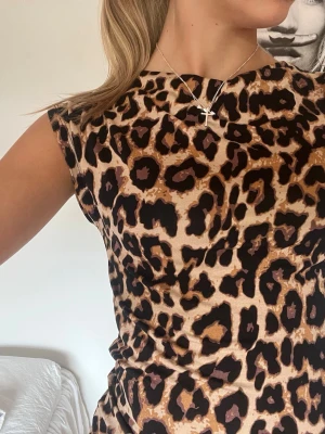 Leopardmönstrad ärmlös topp - Säljer en snygg ärmlös topp med leopardmönster i beige, brunt och svart. Toppen har en tight passform och rund halsringning!💕