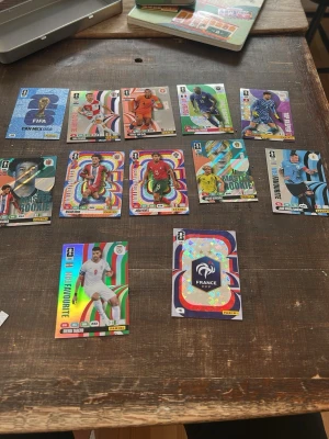Samling Panini fotbollskort VM - Säljer en samling Panini fotbollskort med färgglada och glittriga motiv från olika nationer och spelare, inklusive specialkort som Master Rookie och Limited Edition. Perfekt för dig som gillar att samla på fotbollskort och vill ha unika kort i din samling.