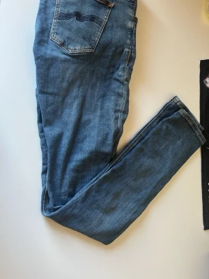 Nudie jeans - Säljer dessa blåa nudie jeans utan slitningar och en slim fit. Kvaliten på dessa jeans är otroligt hög och det finns inga defekter på dem