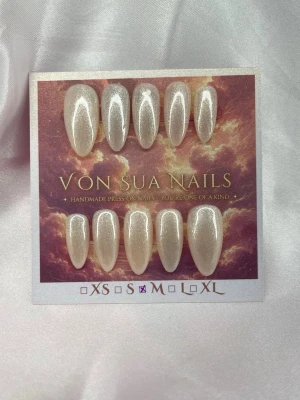 Ivoire (M);Meidum Almond - Set handgjorda press-on naglar i storlek M: 16 mm, 12 mm, 12,5 mm, 11,5 mm, 10 mm. Naglarna har en elegant pärlvit färg med skimrande glittereffekt och är formade i en medium lång almondform. Perfekt för dig som vill ha en lyxig och unik look.