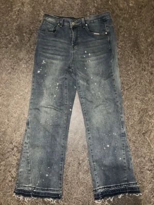 Flared Baggy Jeans I Blå med graffiti  - Säljer size S blåa flared jeans som jag aldrig använt eftersom den är ganska baggy och är direkt inte mitt smak i kläder. Den är ganska bred längst nere vid foten.
