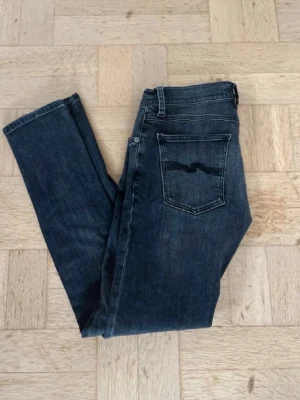 Feta nudie jeans - Snygga nudie jeans med klassisk femficksdesign och diskret vågig detalj på bakfickan. Jeansen har normal midja och raka ben, perfekta till en avslappnad stil. Tillverkade i mjukt denimtyg för skön komfort.