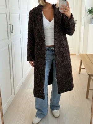 Brun tweedkappa från Esprit - 🤎Snygg lång kappa från Esprit i mörkbrunt melerat tyg.  🤎 Den är tjock och håller dig riktigt varm även under de kallaste vinterdagarna! 🍁 Perfekt för hösten och vintern, enkel att matcha med olika outfits 🍁Passar både S och M  ⭐️ För mer info är det bara att höra av sig! 