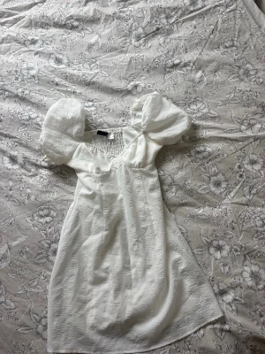 Vit klänning med puffärmar - Fin och gulllig klänning från H&M i storlek S! Köptes för några år sedan och är enbart använd fåtal gånger, den har en liten sminkfläck på ena armen (se bild) men det är inget som syns särskilt mycket🥰