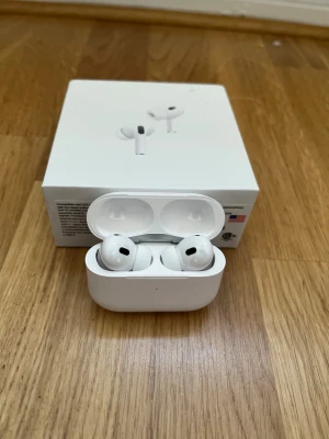 airpods pro gen 2 - Snygga vita trådlösa in-ear hörlurar med laddningsetui. Kompakt design och stilren look, perfekt för musik och samtal på språng. Levereras i originalförpackning. Materialet är plast och silikon för bekväm passform.