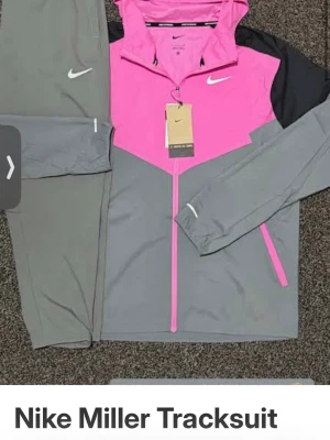 Nike Miller träningsset med huva - Säljer två Nike Miller träningsset. Ena setet är grått och rosa med svarta detaljer, dragkedja och huva. Andra setet är helgrått med dragkedja och huva. Båda har Nike-logga på bröst och byxa, samt elastisk midja. Perfekt för träning eller chill.