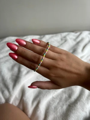 Färgglatt pärlarmband med kedja - Säljer ett armband med små färgglada pärlor i turkos, gult, silver och rosa. Armbandet har även en tunn silverfärgad kedja som ger en snygg kontrast till pärlorna. Perfekt accessoar för att addera lite färg till din stil.💕