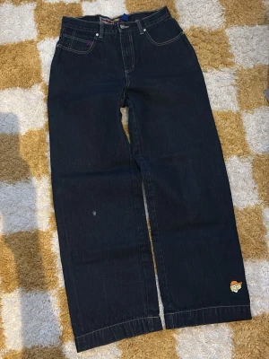 Vintage no excuses jeans - Säljer ett par mörkblå jeans från no excuses med raka, breda ben och klassisk femficksdesign. Jeansen har kontrastsömmar och no excuses -logga på benet och bakfickan. Perfekta för en avslappnad och trendig streetstil. (Mått: [Ytterbenslängd 109 cm] [Midja 39 cm] [Benöppning 26 cm]