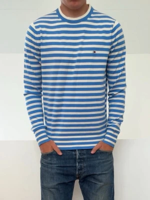 Ljusblå Randig Tommy Hilfiger tröja - Ljusblå Randig Tommy Hilfiger tröja är i strl M men sitter mer som en S! Mycket Bra skicka utan nåra defekter och hör gärna av er vid frågor elr funderingar!!