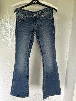 Bootcut jeans från True Religion - Blå bootcut jeans från True Religion. Jeansen har normal midja, stretch och utsvängda ben.