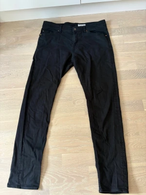 Svarta jeans från Tiger of Sweden - Snygga svarta jeans från Tiger of Sweden med klassiska stylen Evolve-33/34