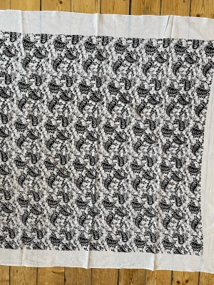 Vit sjal med svart paisleymönster 106X106 cm, i bomull - Säljer en stor, tunn sjal i vitt med svart paisleymönster och blommor. Sjalen har en bred, enkel kant runt om. Materialet är bomull. Perfekt skick!