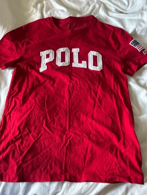 Röd t-shirt med USA-detalj - T shirt med text och USA flagga på ena ärmen