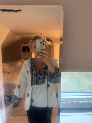 Blus från zara  - Luftig vit blus med mörkblå detaljer och v-ringning i storlek XS. Vida ärmar med dekorativa detaljer och avslappnad passform. Perfekt till jeans eller kjol för en chill look. Väldigt luftig och skön att använda när det är varmt. Har bara användt 1-2 gånger så nästan som ny.