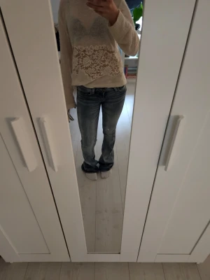 Low waist bootcut jeans - Säljer ett par blå bootcut jeans med snygga tvättade detaljer och klassisk femficksmodell. Jeansen har låg midja och är i ett mjukt denimtyg som sitter skönt. Använda ett fåtal gånger och inga defekter