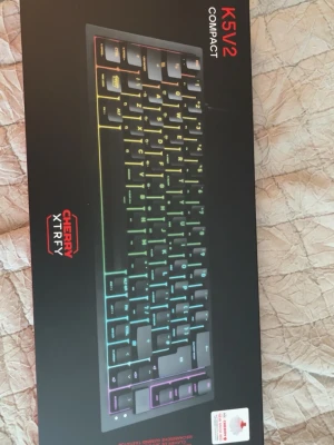 Xtrfy K5V2 Compact RGB gaming tangentbord - Säljer ett Xtrfy K5V2 Compact mekaniskt tangentbord med RGB-belysning och Cherry-switchar. Tangentbordet är svart med regnbågsfärgad bakgrundsbelysning och har en kompakt design som passar perfekt för gaming och skrivbordet.