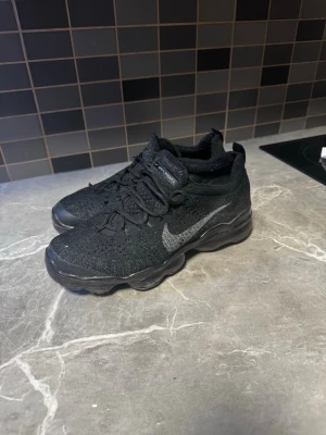 Svarta vapormax  - Säljer ett par riktigt fräscha och helsvarta VaporMax. Grymt sköna sneakers som passar till allt! Flyknit-materialet gör dem superlätta och luftiga, och den ikoniska dämpade sulan ger extremt bra komfort hela dagen. 