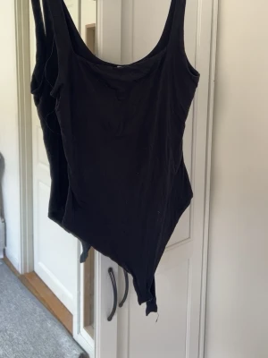 Svart basic body med breda axelband - En enkel och stilren svart body med breda axelband och rundad halsringning. Tillverkad i mjukt material som sitter tight mot kroppen. Kom med prisförslag!💕🙏