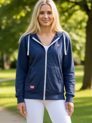 Mörkblå hoodie med dragkedja, strlk Small - Mörkblå hoodie med vit dragkedja och vita snören i huvan. Två stora fickor framtill och små broderade detaljer på bröstet och fickan. Mjuk bomullskänsla och ribbade muddar vid ärmar och nederkant. Stor röd detalj på huvan baktill. Strlk Small. Bra skick - se bilder för egen bedömning. Modellen visar likadan ny hoodie.