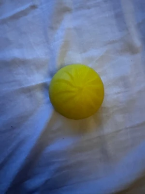En gul Squishy dumpling - En rund, gul stressboll i mjukt och töjbart gummi. Perfekt att klämma på när man vill slappna av eller behöver något att sysselsätta händerna med. Bollen är enkel att ta med sig och har en slät yta med lätt struktur.