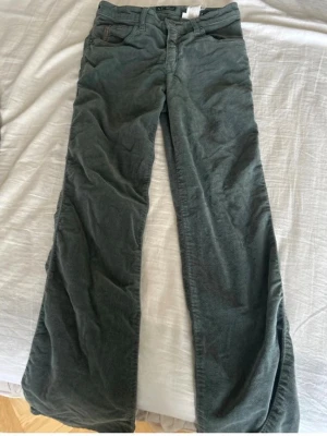 Mörkgröna manchesterbyxor Armani - Snygga mörkgröna manchesterbyxor från Armani med klassisk femficksmodell och raka ben. Byxorna har en mjuk och skön manchesterstruktur och detaljerade sömmar. Perfekta för dig som vill ha en stilren och trendig look. Liten fläck på baksidan men ingenting som syns tydligt när man använder. Hör av dig vid frågor, pris kan diskuteras.