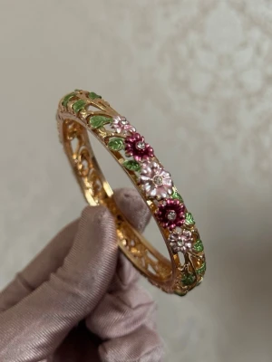 Guldfärgat armband med blommor - Unikt guldfärgat armband med detaljerade blommor samt gröna blad. Höstens armband!