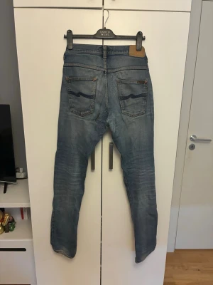Nudie jeans grim tim, många lagningar - Nudie jeans modell: grim tim, tvätt ink navy, strl. 32/34. Många lagningar sedan innan. 1 hål på rumpan.