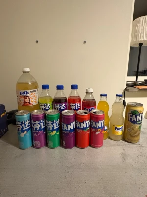 Samling Fanta burkar och flaskor - Unik samling Fanta med 12 olika burkar och flaskor i flera färger och smaker. Innehåller både plastflaskor och aluminiumburkar i nyanser av blått, grönt, lila, rött, gult och guld. Perfekt för dig som gillar att testa nya drycker eller vill ha något coolt till samlingen.