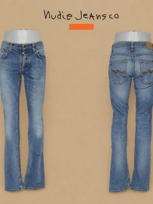 Nudie jeans - Snygga blå bootcut jeans från Nudie Jeans med klassisk femficksdesign och orangea sömmar. Jeansen har en lätt tvättad look och subtila slitningar på låren. Tillverkade i bomull med en bekväm passform och normal midja.