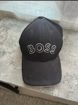 Hugo boss keps  - Oanvänd Hugo boss keps, vet ej storlek. stått i en hylla så är dammig.