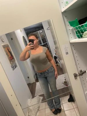 Beige tight crop top med kort ärm - Säljer en beige crop top med tight passform och korta ärmar. Toppen har en fyrkantig ringning och är gjord i ett stretchigt material som sitter snyggt på kroppen. Perfekt att matcha med jeans eller kjol för en enkel och trendig look.