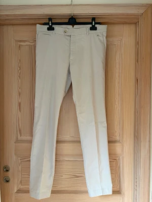 J.Lindberg chinos - Beige chinos från J.Lindberg endast använda fåtal gånger. Byxorna har en tight fit strlk. W32 L32