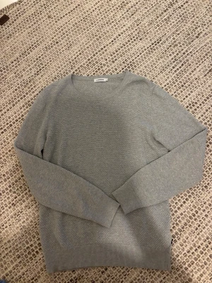 Ljusgrå stickad tröja J.Lindeberg - J.Lindeberg stickad tröja i grått, storlek M 🤍 Snygg och stilren modell med fin struktur i materialet. Perfekt till både vardags och lite mer uppklätt. Tröjan är i fint skick och utan några tydliga skador eller fläckar. 📏 Storlek: M 🎨 Färg: Grå 🏷️ Märke: J.Lindeberg 📦 Skickas snabbt och välpackad Hör gärna av dig vid frågor! 