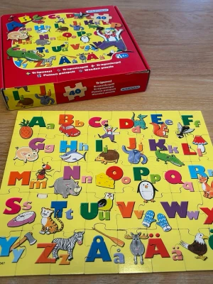 Färgglatt ABC-träpussel från Kärnan - Säljer ett färgglatt ABC-pussel i trä från Kärnan med 40 bitar. Pusslet har bokstäver i olika färger och illustrationer av djur och föremål på gul bakgrund. Perfekt för att lära sig alfabetet på ett roligt sätt! Två av pusselbitarna har mindre skav, se bild, inget som påverkar funktionen dock. Djur och rökfritt hem