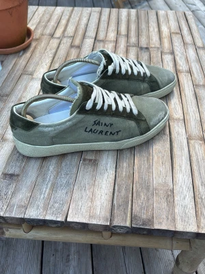 Saint Laurent skor - Säljer ett par gröna sneakers från Saint Laurent i mjuk mocka. Skorna är storlek 41 och är 26,5cm Med 0 defekter. Skriv vid minsta fundering. 